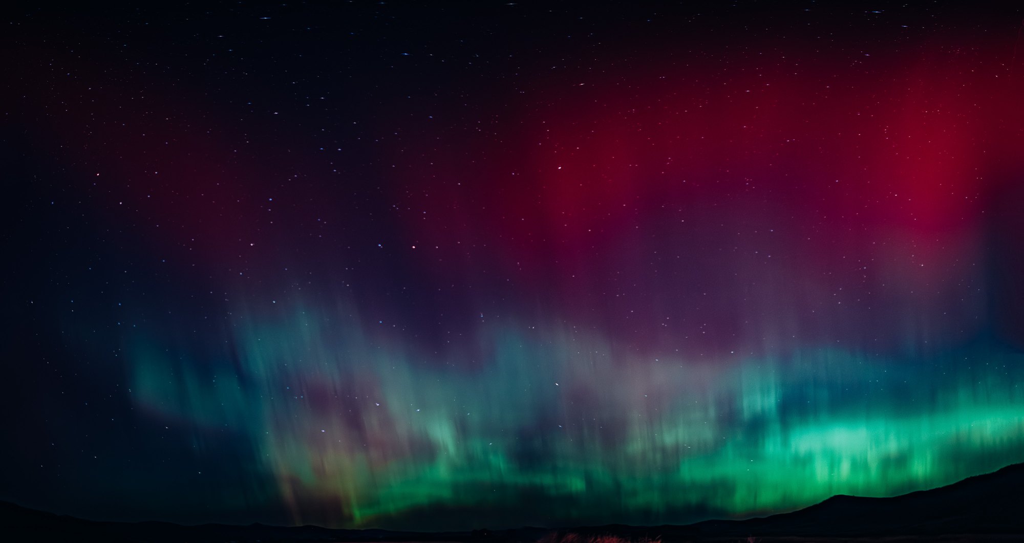 Aurora over a dark ridge